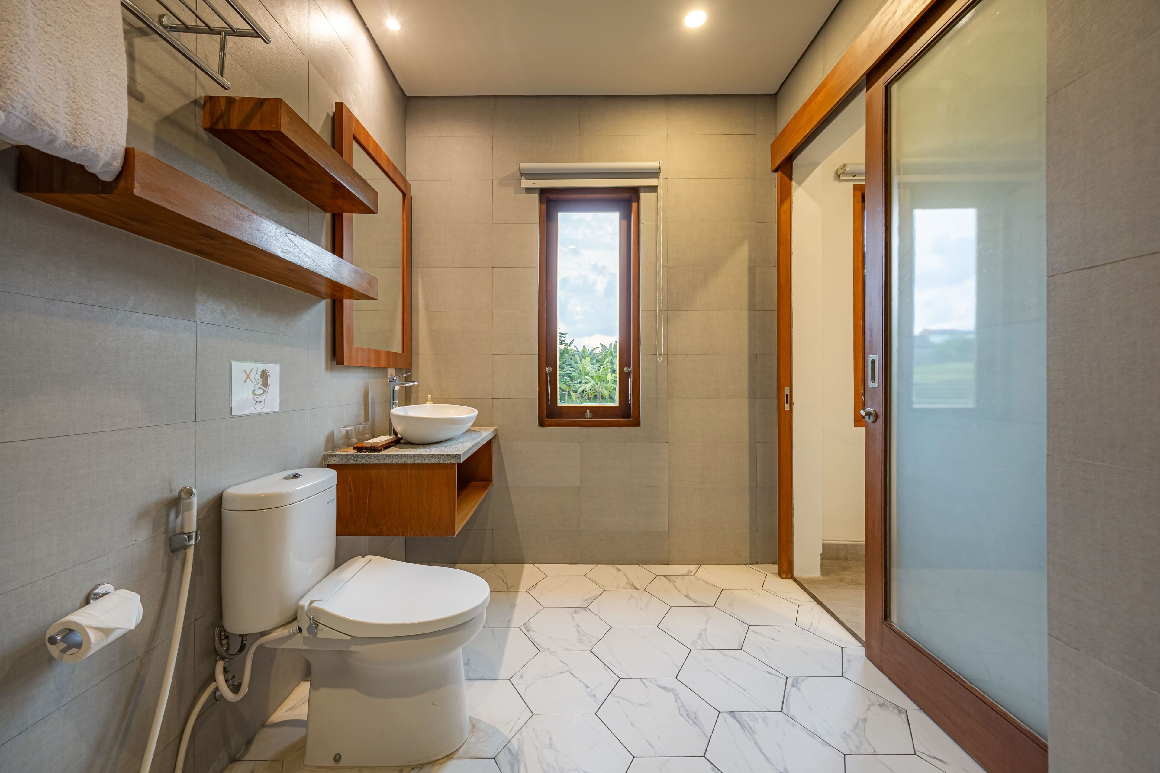A modern bathroom with a toilet, sink, and shower area.
