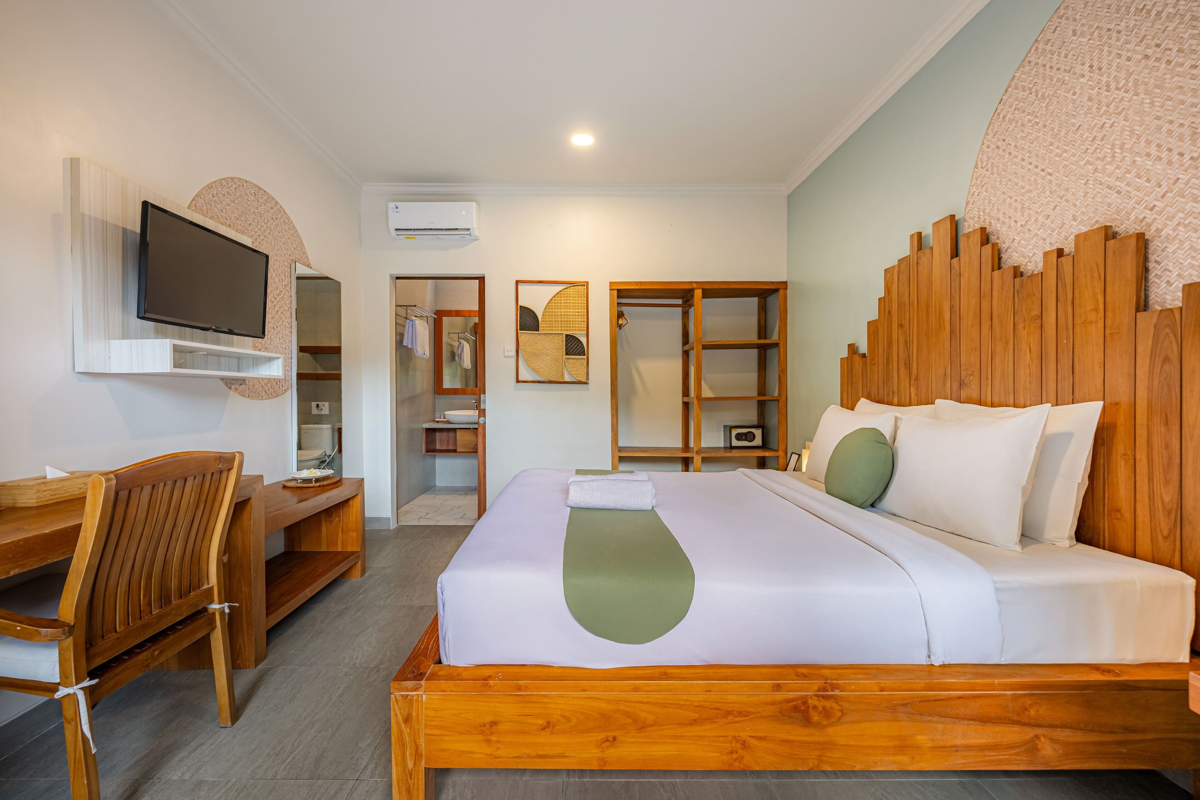 Una habitación de hotel con una cama de madera, un escritorio, una silla, un televisor y un armario.