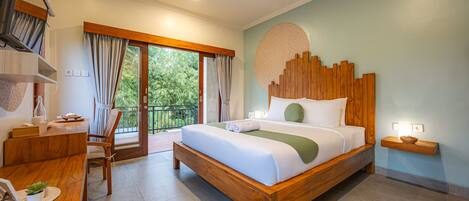 A spacious bedroom with a wooden bed, a desk with a chair, a small table with a bowl, and a large window with curtains.