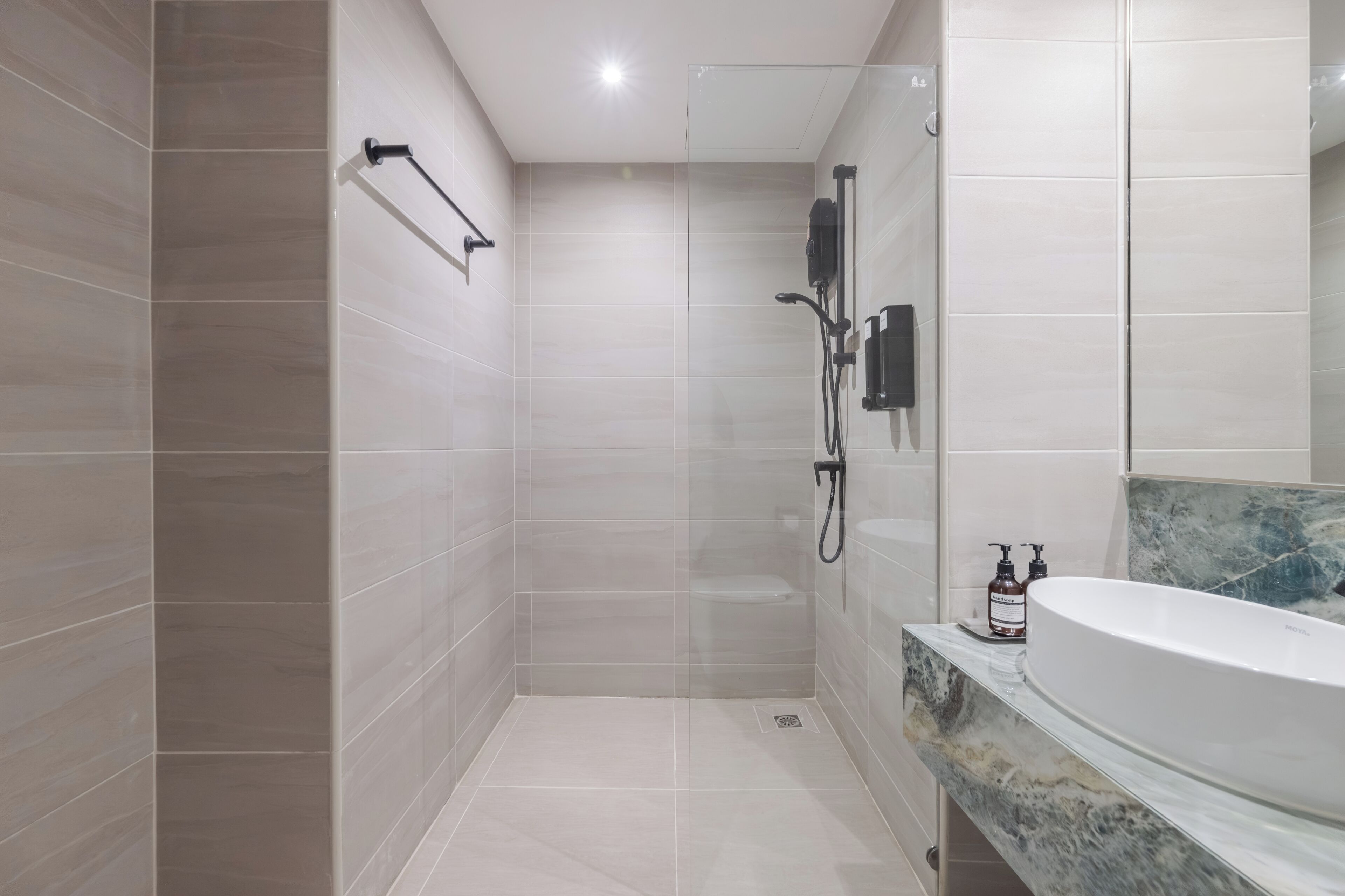 A modern bathroom with a walk-in shower, a toilet, and a large bathtub.