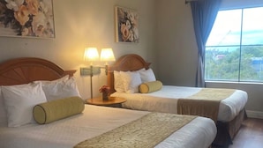 A hotel room with two beds, a large window, and floral artwork on the walls. - Beautiful Pool view -near Theme parks (Orlando)