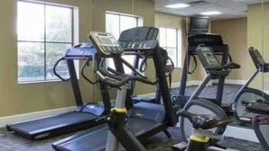 A gym with treadmills and elliptical machines, carpeted flooring, and large windows. - Beautiful Pool view -near Theme parks (Orlando)