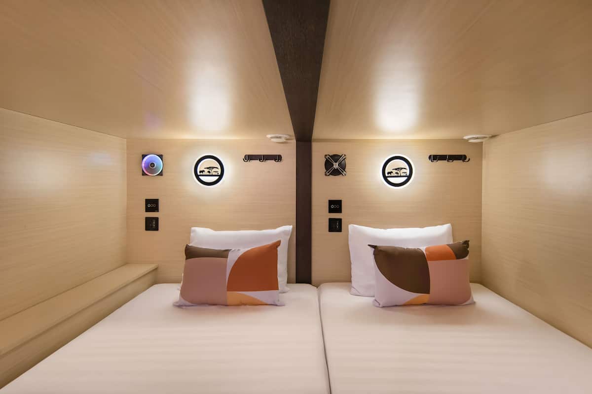 Een moderne hotelkamer met twee bedden, elk met een bijzonder kussens ontwerp.