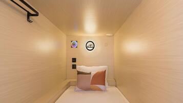 Una habitación pequeña y acogedora con una cama, una lámpara en la pared y un adorno circular.