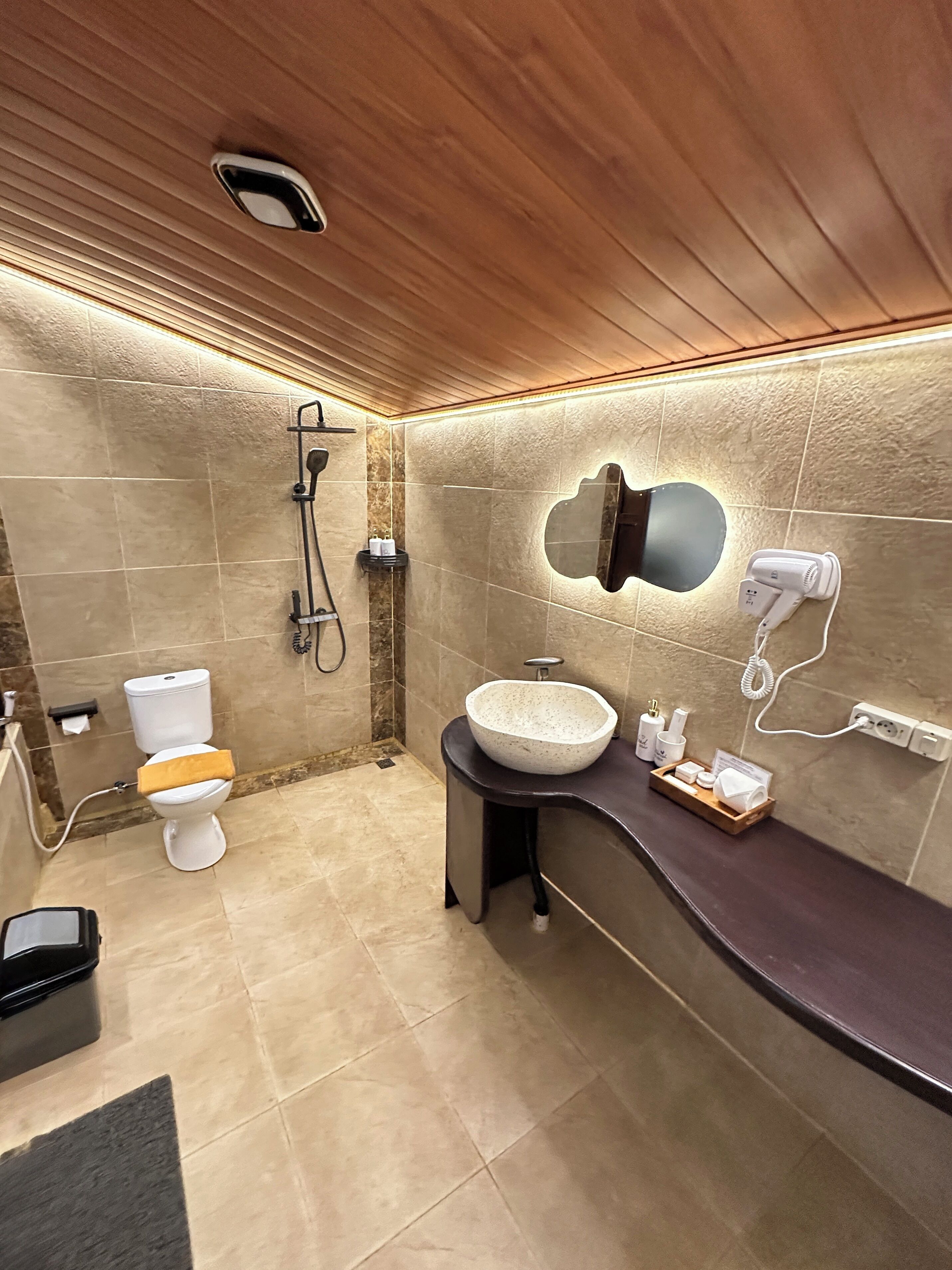 Un baño moderno con inodoro, lavamanos y ducha.