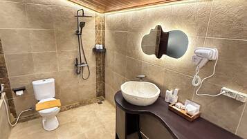 Un baño moderno con inodoro, lavamanos y ducha.