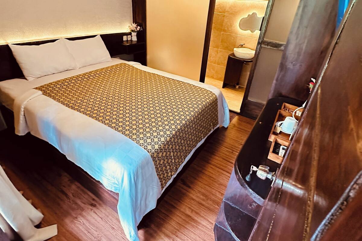 Une chambre d’hôtel avec un lit, une table de chevet et un miroir.