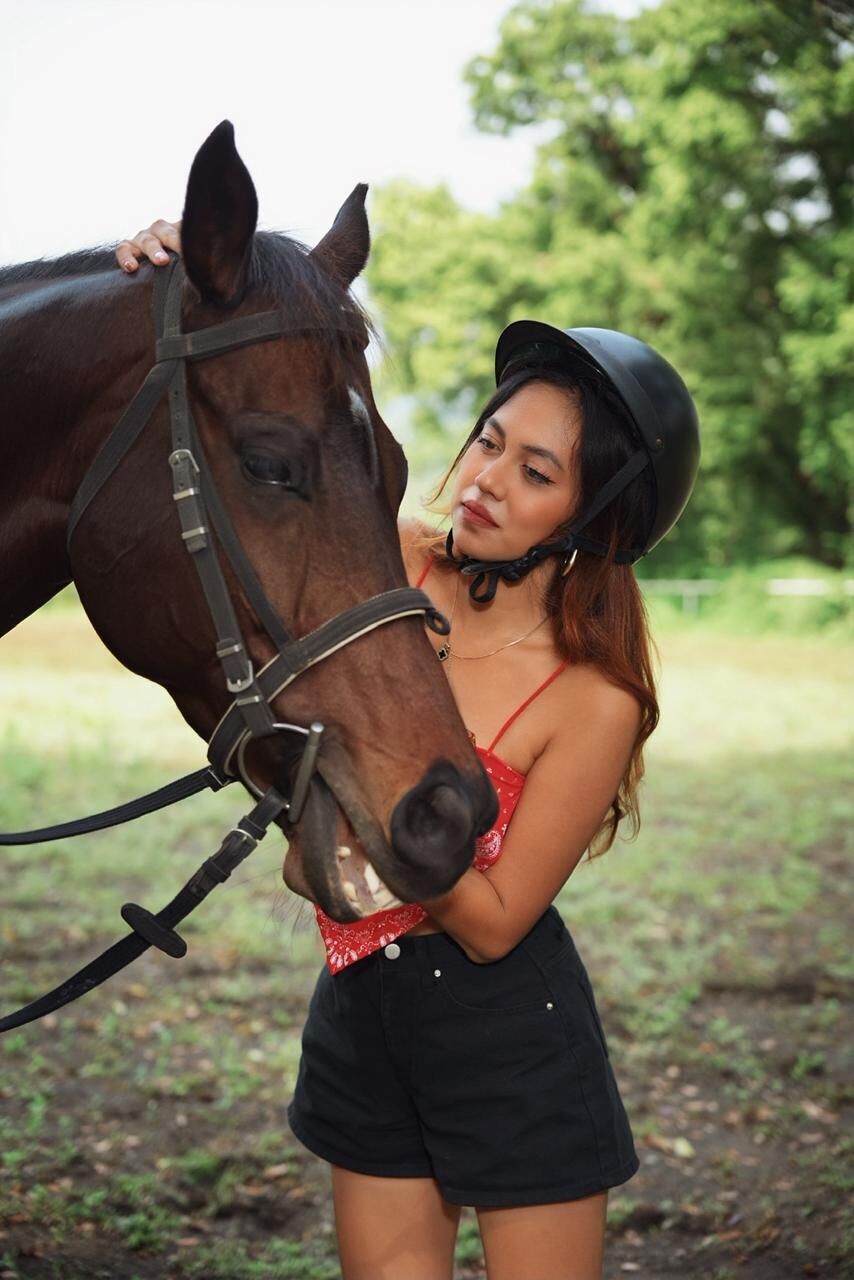 Een persoon met een paard in een natuurlijke omgeving.