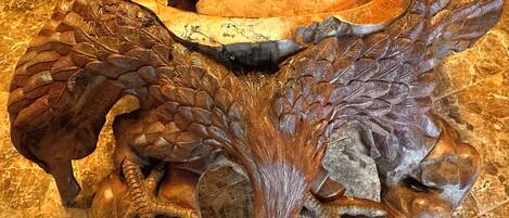 A detailed wooden sculpture with intricate carvings of a lion's head and paws.