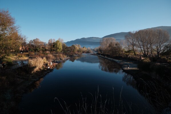 A calm river with trees and a distant mountain range. - Shaxi Ancient Town Chang Le Li Chinese Courtyard Hotel (Dali)