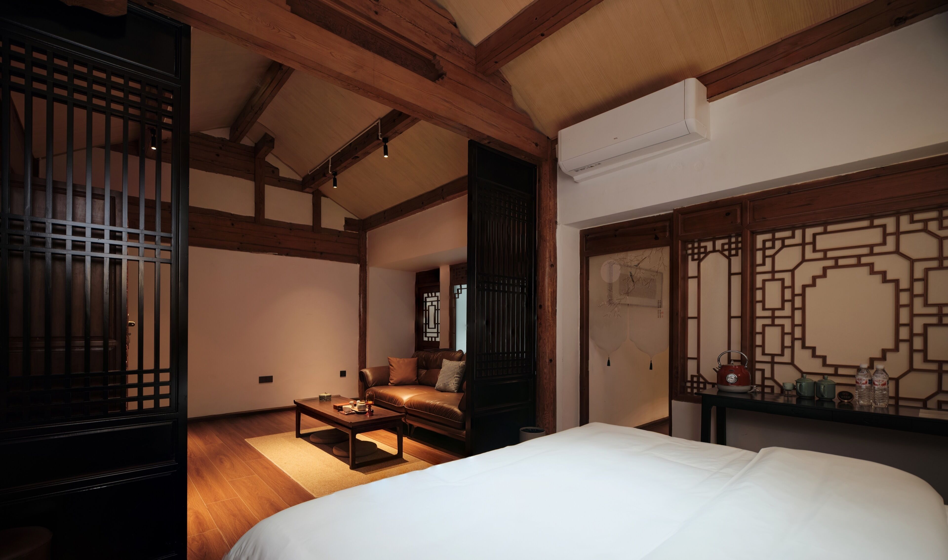 A traditional Japanese-style room with a bed, a wooden table, and a sofa.