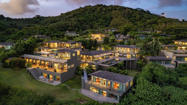 Un complex residencial modern amb diverses cases connectades, grans finestres i espais exteriors.