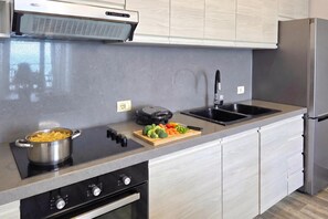 A modern kitchen with a built-in oven, a stovetop, a sink, and a refrigerator. - Beachfront & Sea View Apartment 101, Durres, Albania (Durres)