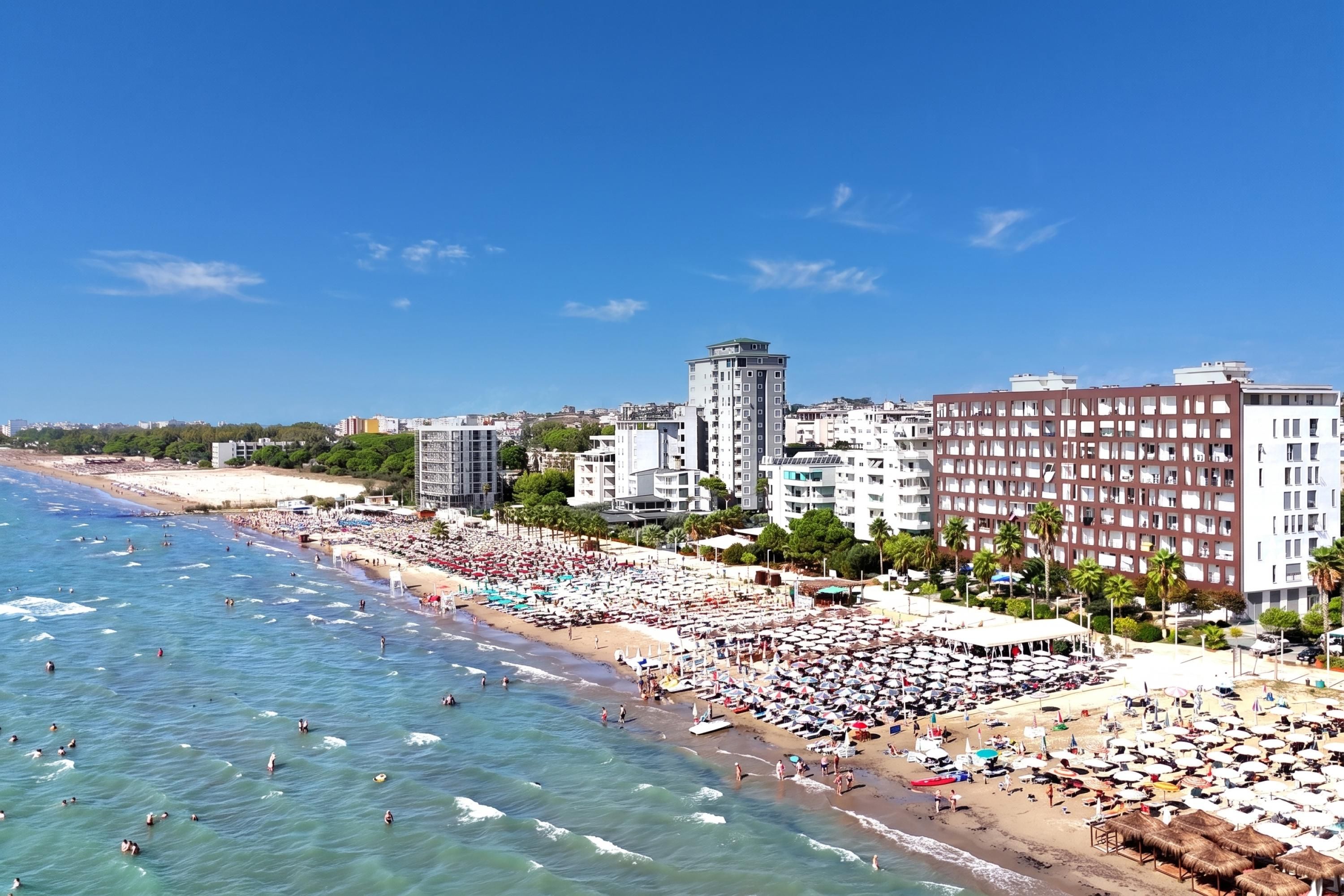 Un paisaje urbano costero con playa, edificios y cielos despejados.
