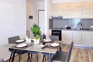 A modern kitchen with a built-in oven and a dining area with a table set for two.
