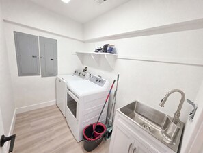 A laundry room with a washing machine, dryer, and a sink. - Ocean front oasis full remodel hot tub heated pool Wild horses 8 bed 8 bath (Corolla)
