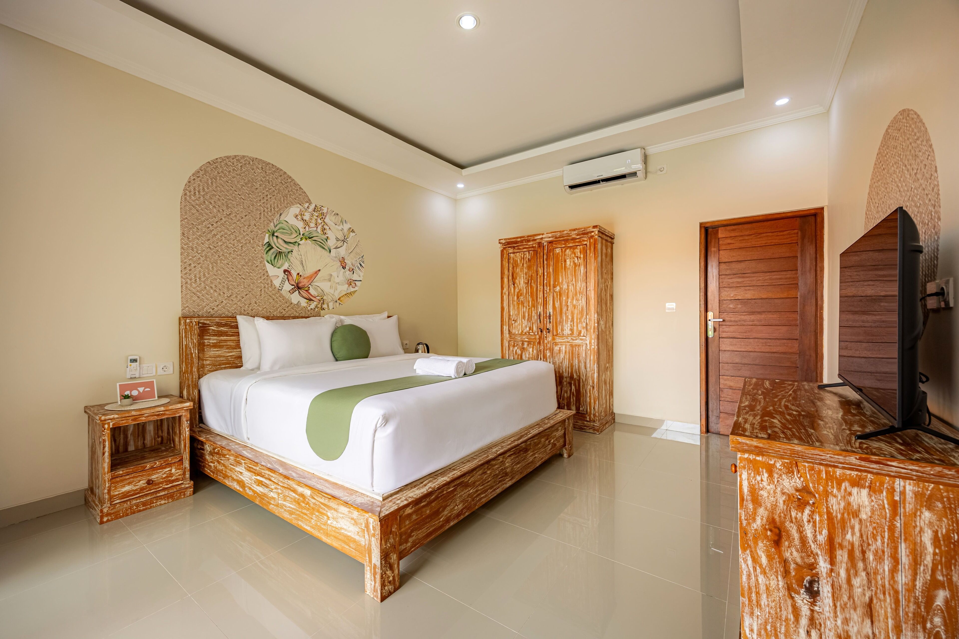 A bedroom with a wooden bed, a nightstand, a wardrobe, and a television.