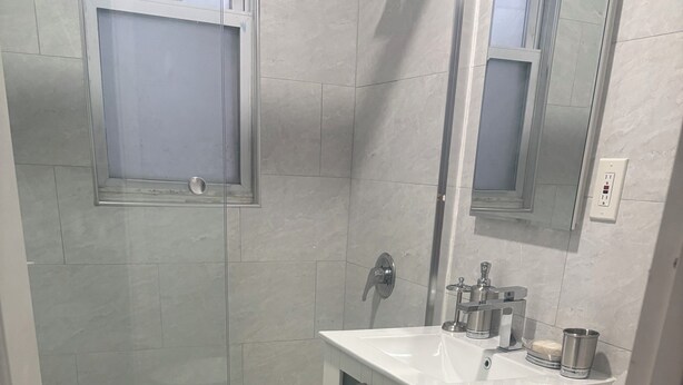 A bathroom with a bathtub, toilet, sink, and a mirror.