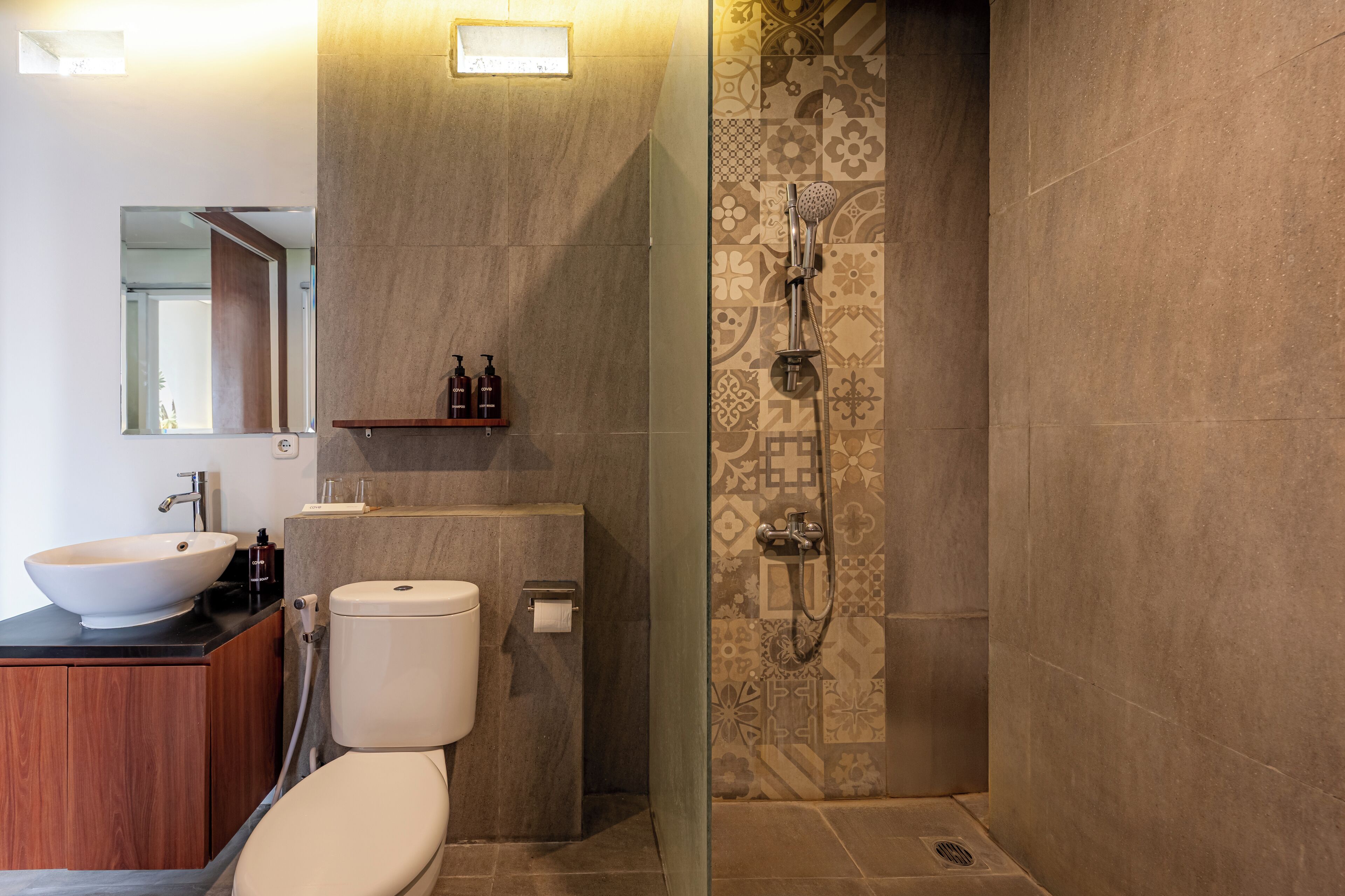 A modern bathroom with a large sink, toilet, and shower.