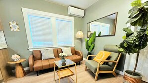A living room with a sofa, a chair, a coffee table, a potted plant, and a lamp. - Charming & Cozy Home Near Caltech PCC & Pasadena Convention Center King-size bed (Pasadena)
