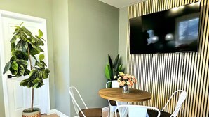 A dining area with a round wooden table, white chairs, and a potted plant. - Charming & Cozy Home Near Caltech PCC & Pasadena Convention Center King-size bed (Pasadena)