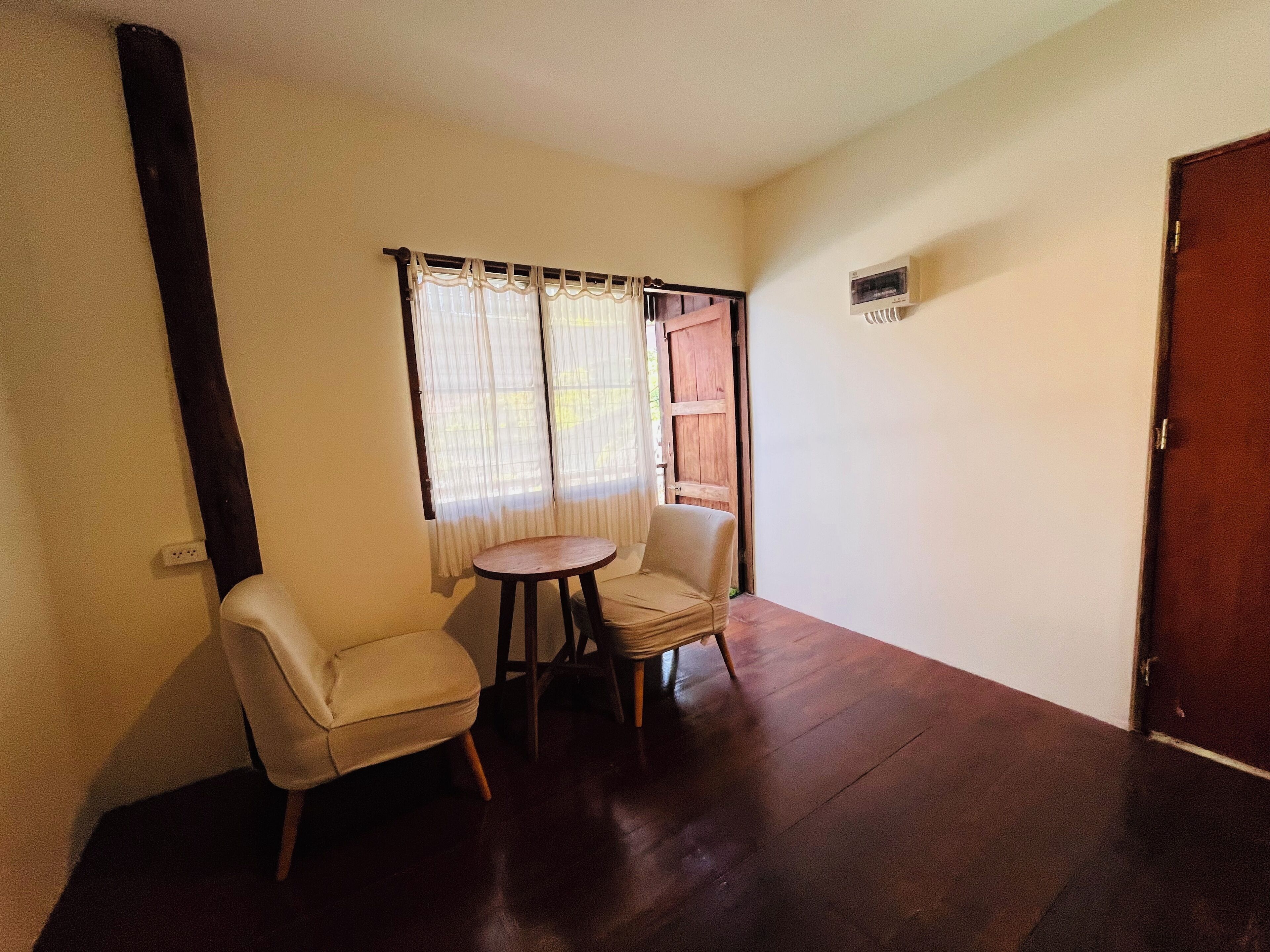 A room with two chairs, a small table, and a door.