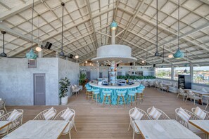 A spacious outdoor bar area with high ceilings and multiple seating options. - XO Canggu - Adults Only (Canggu)