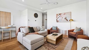 A modern living room with a sectional sofa, two armchairs, a coffee table, and a painting on the wall. - Ocean Views Kings Beach (Kings Beach)