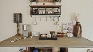 A kitchen counter with a coffee maker, a kettle, a tray with sugar and a honey dipper, a mug, a spice jar, a small pumpkin, and a decorative sign. - Wellness at the Ranch Retreat! 2 Bedroom 2 Bath Oasis with outdoor living space (Acampo)