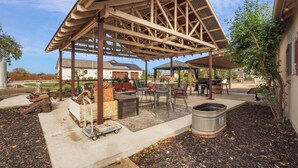 A covered outdoor patio with a pergola structure, outdoor furniture, and a fire pit area. - Wellness at the Ranch Retreat! 2 Bedroom 2 Bath Oasis with outdoor living space (Acampo)