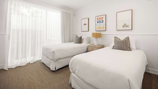 A hotel room with two beds, a ceiling fan, and artwork on the wall. - Thalasa Two at Sunshine Beach (Sunshine Beach)
