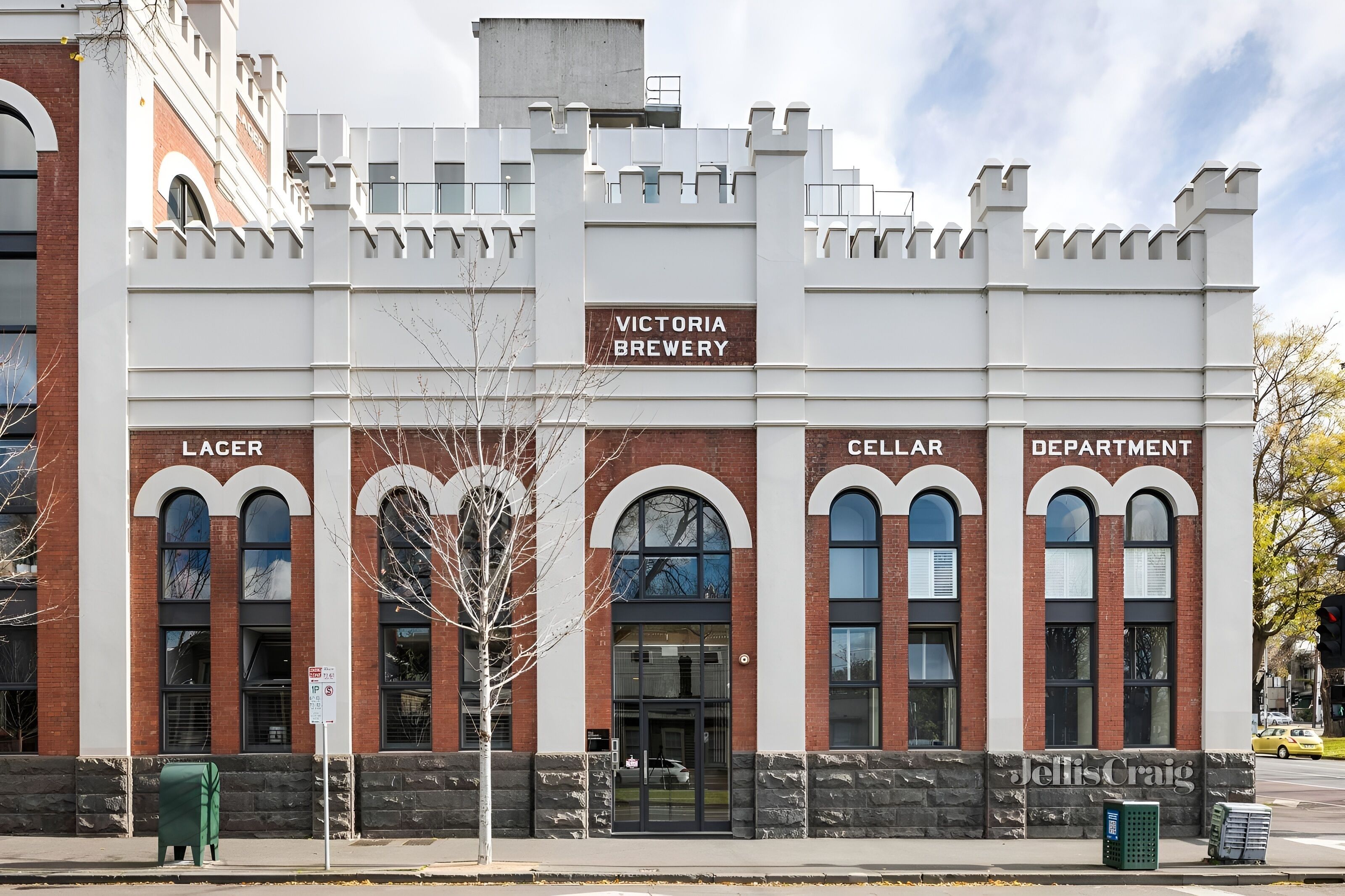 A Victorian-style building with a sign reading "Victoria Brewery" and sections labeled "Lager," "Cellar," and "Department."