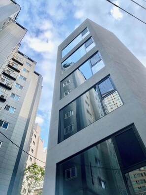 Un immeuble moderne de grande hauteur, doté de nombreux étages, de grandes fenêtres et de balcons.
