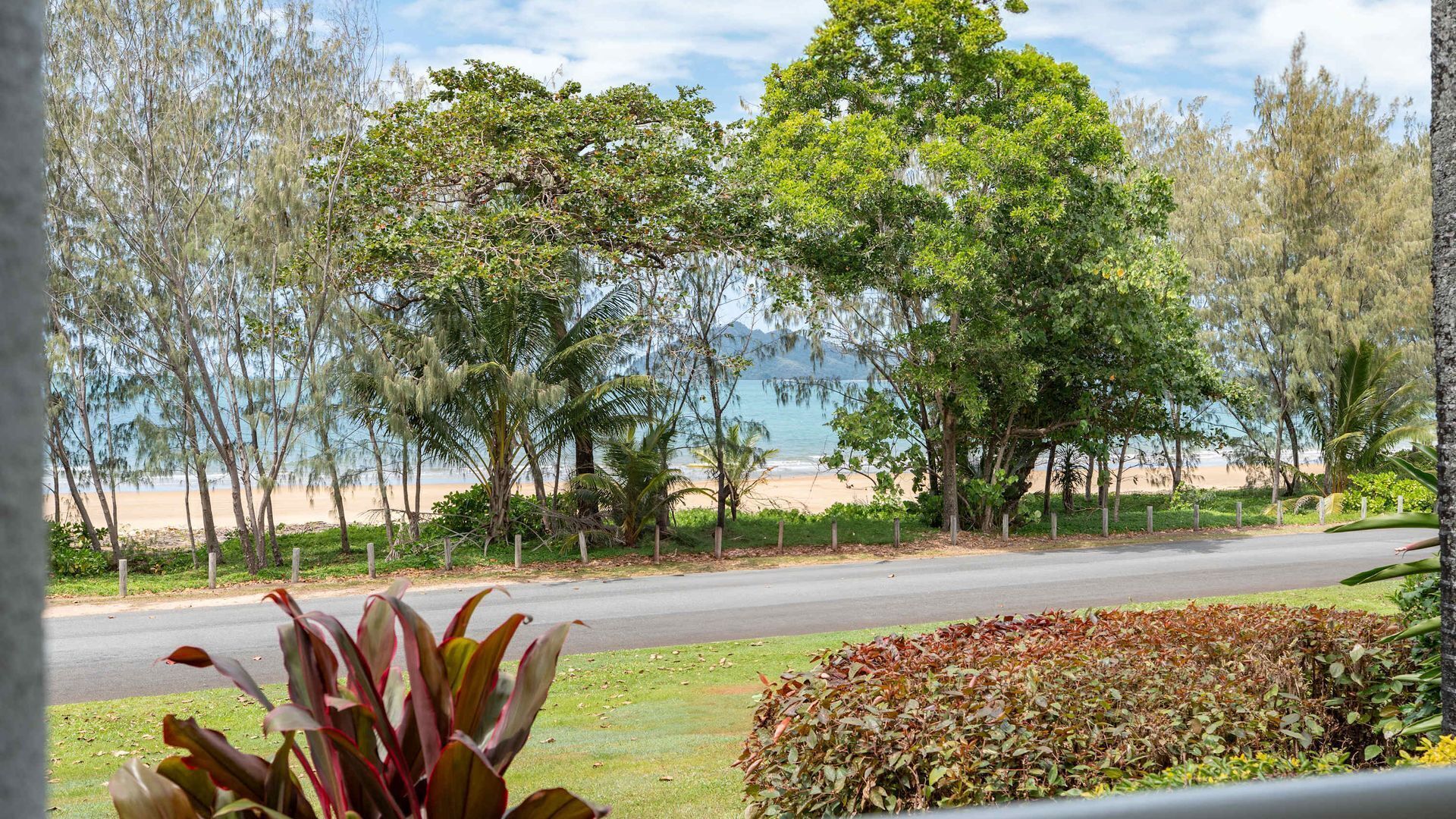 A coastal road with a view of the beach and ocean.