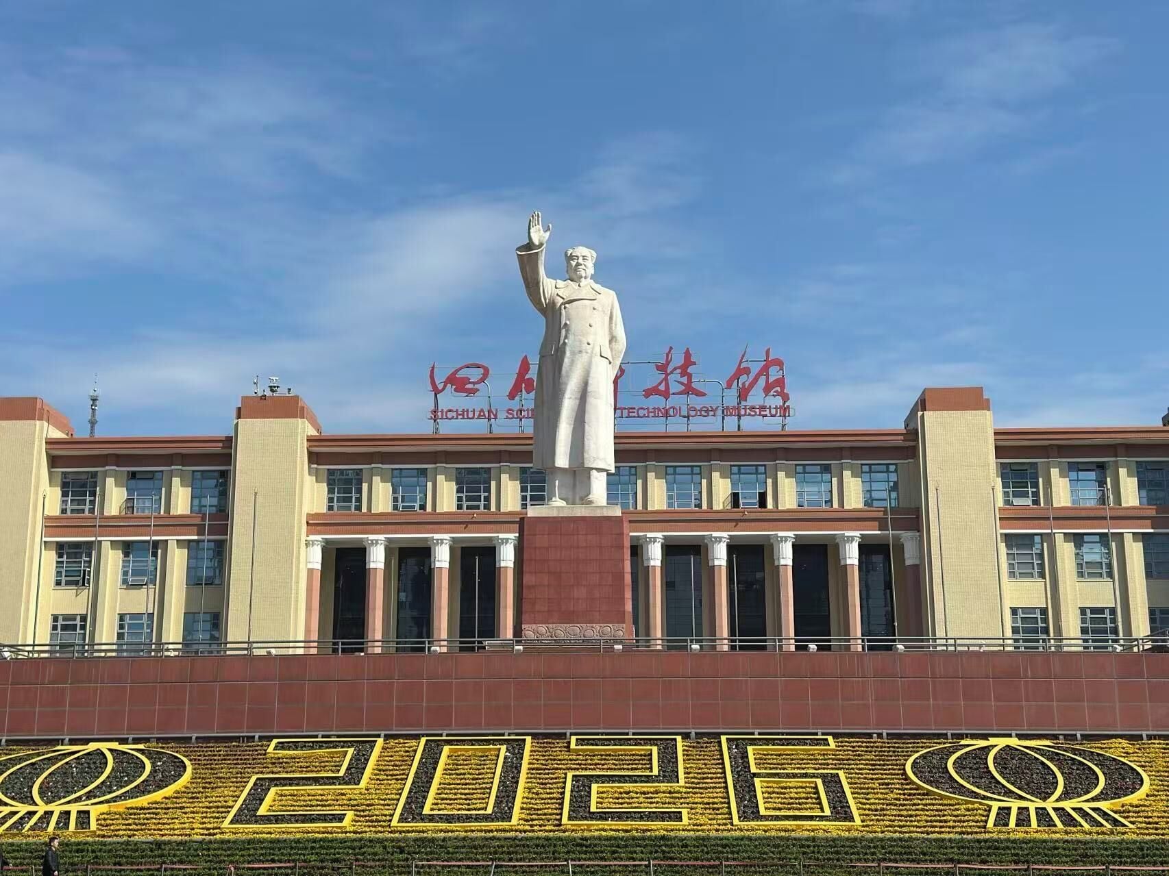 Un edificio con una gran estatua en la fachada, columnas y un cartel que dice 'Technology Museum'.