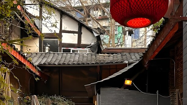 An outdoor dining area with bamboo chairs and tables, surrounded by plants and traditional architecture. - CYBO Junting Shangpin Hotel (Chengdu Chunxi Road Tianfu Square Branch) (Chengdu)