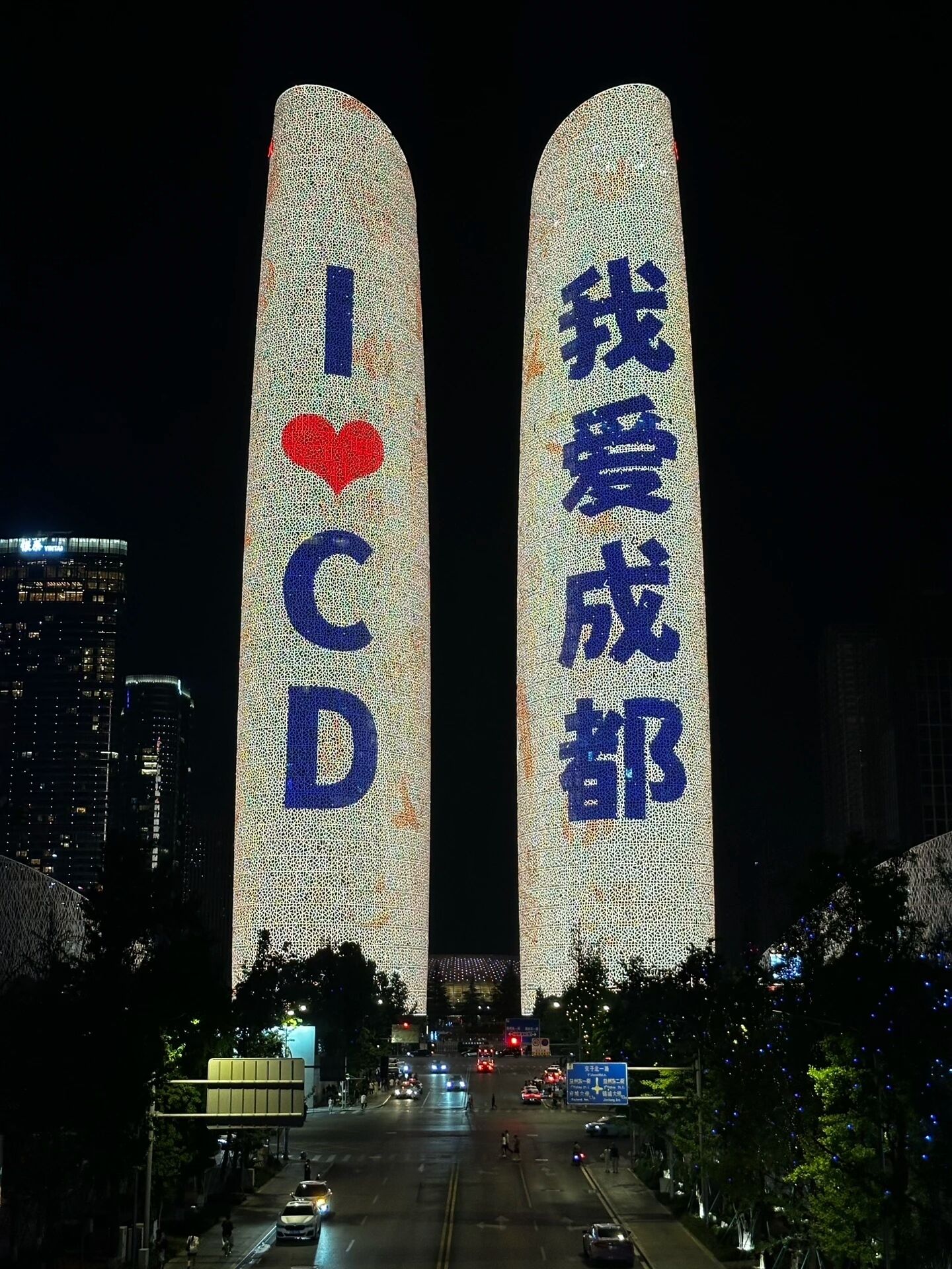 A building with illuminated vertical structures displaying text and a heart symbol.