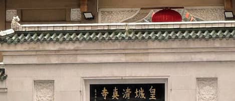 A traditional building with ornate roof tiles and a sign with Chinese characters.