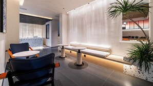 A modern interior with a seating area, a plant, and a wall-mounted shelf. - CYBO Junting Shangpin Hotel (Chengdu Chunxi Road Tianfu Square Branch) (Chengdu)