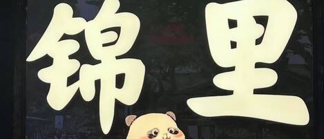 Un cartel con grandes caracteres chinos y un panda de dibujos animados.