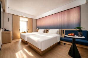 Een moderne hotelkamer met twee bedden, een bank, een kleine tafel en een televisie.