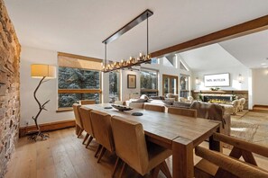 A spacious living area with a wooden dining table, sofas, and a fireplace. - 11 Bedroom Duplex - Vail Village (Vail)