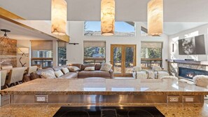 A spacious living area with a large island, a fireplace, and a television. - 11 Bedroom Duplex - Vail Village (Vail)