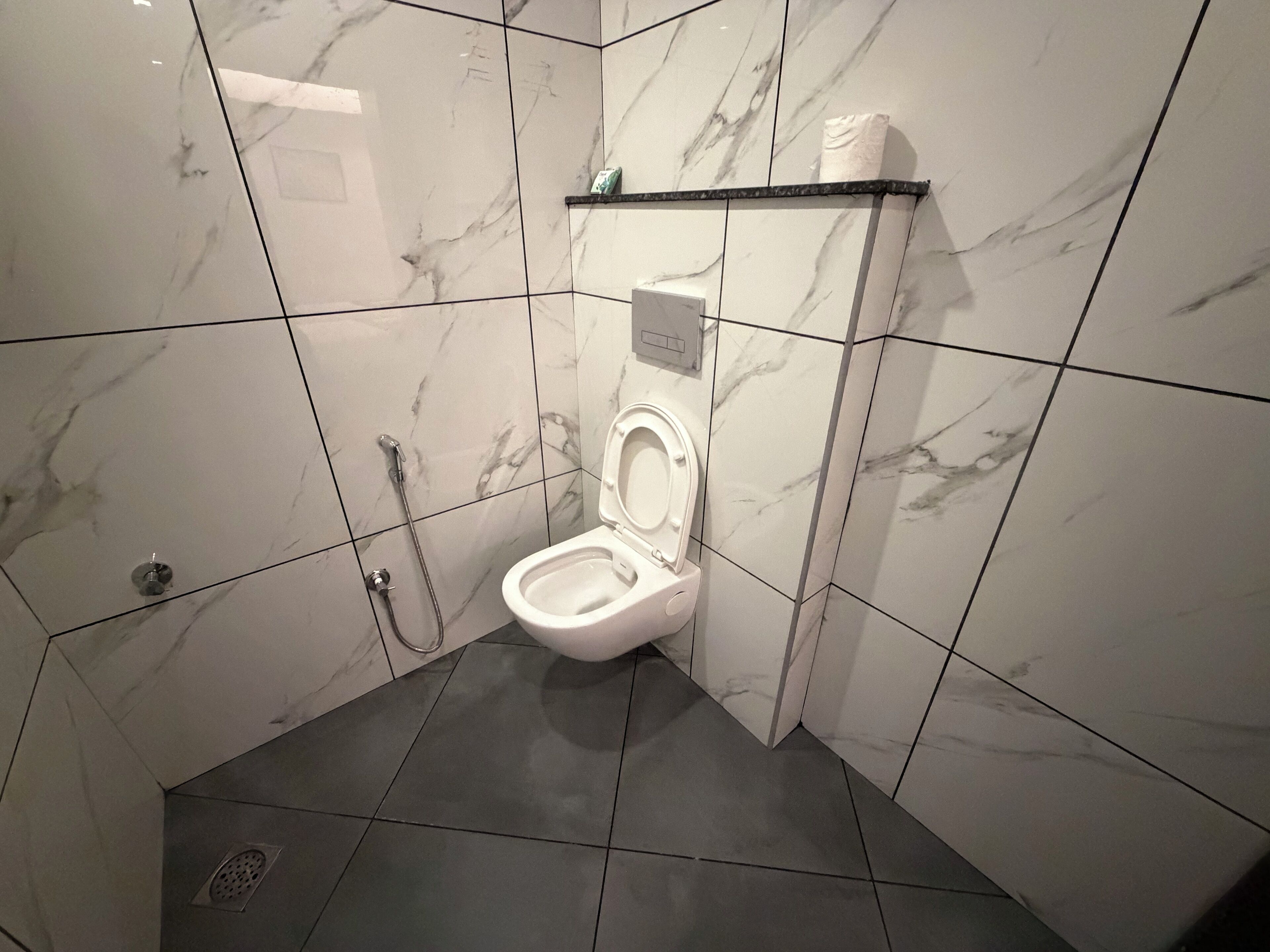 Un baño con inodoro, ducha y lavamanos.