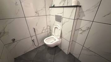 Un baño con inodoro, ducha y lavamanos.