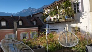 A residential area with a balcony, a chair, and a view of mountains. - Apartment Lauben- Alpstay (Merano)