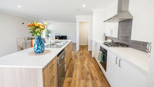 A modern kitchen with a central island, wooden cabinets, a stainless steel sink, and a gas stove. - StayAU 5 Beds Pet-friendly Haven Escape in WA (Secret Harbour)