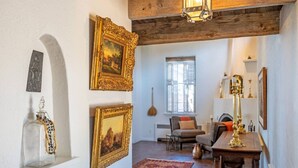 Une pièce avec un plafond en bois, une cheminée, une table à manger et un tapis rouge.