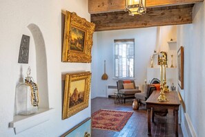 A room with a wooden ceiling, a fireplace, a dining table, and a red rug. - Cinco Chimineas- Indoor Pool, Walk to Plaza (Santa Fe)