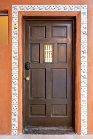 A brown door with a decorative tile border and a small window. - Cinco Chimineas- Indoor Pool, Walk to Plaza (Santa Fe)